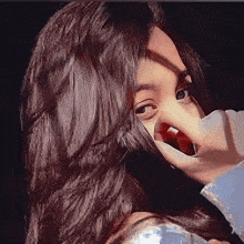 a close up of a woman covering her face with her hands