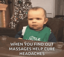 a baby is sitting in a high chair with a christmas tree in the background .