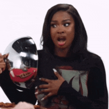 a woman with a surprised look on her face is holding a metal object
