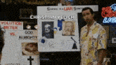 a man is standing in front of a sign that says `` science is a liar somethin '' .