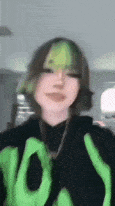 a girl with green hair is wearing a black shirt with the word low on it