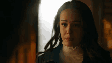 a close up of a woman 's face with a turtleneck and a leather jacket