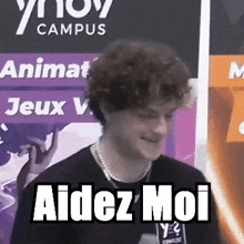 a man is standing in front of a sign that says `` aidez moi '' .