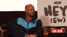 a man sitting in front of a sign that says hey