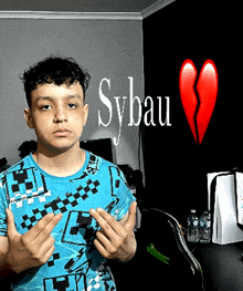 a young man in a blue shirt is standing in front of a broken heart and the word sybau