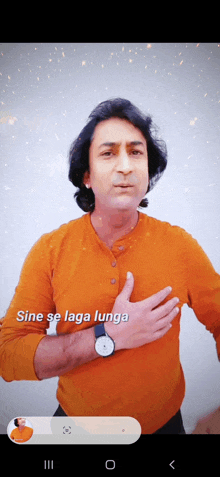 a man in an orange shirt holds his hand to his chest and sings sine se laga langa