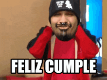 a man wearing a red shirt and a black hat says feliz cumple on the bottom