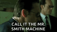 a man in a suit and tie is talking to another man in a suit .