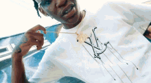 a man wearing a louis vuitton t-shirt and a necklace