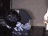 a man in a black shirt is singing into a microphone in a dark room