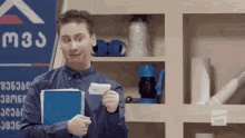 a man is holding a notebook and a piece of paper in front of a sign that says m3 .