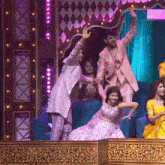 a group of people are sitting on a stage and one of them is holding a snake