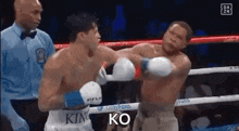 two men are boxing in a ring and one of them is wearing a shirt that says king on it .