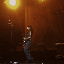 a woman singing into a microphone in front of a banner that says beaby