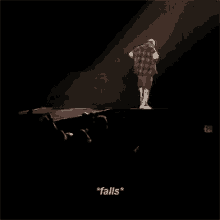 a man in a plaid shirt is singing into a microphone on a stage while a crowd watches ..