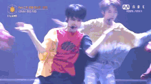 two young men are dancing on a stage with a mnet logo in the corner