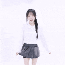 a girl with braided hair wearing a white shirt with a red embroidered logo