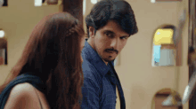 a man and a woman are standing next to each other and looking at each other