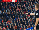 a referee stands in front of a crowd of people watching a soccer game