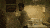 a man in a white shirt stands in a kitchen next to a white stove