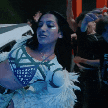 a woman wearing a necklace with the letter o on it is dancing