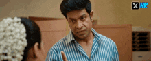 a man in a blue striped shirt is talking to a woman