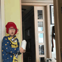 a boy wearing a red hat with the olympic rings on it is holding a vase