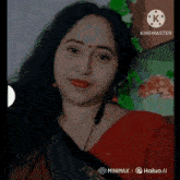 a woman wearing a red saree and ear buds is being filmed by kinemaster