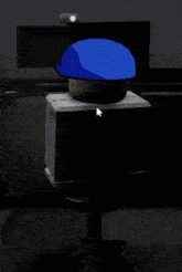 a blue hat is sitting on top of a computer