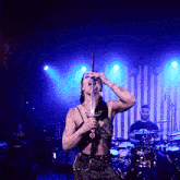 a woman singing into a microphone while holding a sword in her mouth
