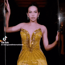 a woman in a yellow dress is standing in front of a glass door