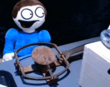 a cartoon character in a blue shirt is sitting in a trap