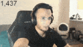 a man wearing headphones is sitting in a chair with the number 1,437 on the bottom