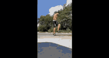 a man without a shirt is jumping a jump rope on the side of the road .