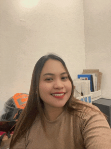 a woman taking a selfie in a room with a helmet in the background that has the letter g on it