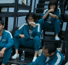 a group of people are sitting on stairs and one of them has 218 on their jacket