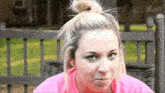 a woman in a pink shirt making a face