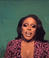 a drag queen is wearing a pink and black dress and earrings .