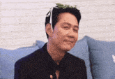 a man wearing a black suit and tie with a flower on his head