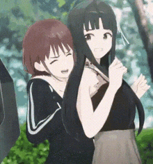 a couple of anime girls are standing next to each other in a park .