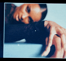 a blurry picture of a woman laying down with her hand on her shoulder