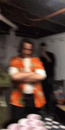a blurry image of a man in an orange shirt