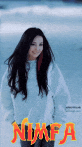 a woman in a white sweater is standing in the snow with the word nimfa on the bottom right