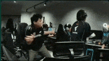 a group of people are sitting in chairs in a room with a lot of computers .