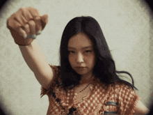 a woman with long black hair is making a fist