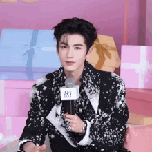 a man is holding a microphone with the letter s on it