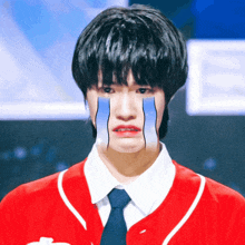 a man in a red shirt and tie is crying with tears coming out of his eyes