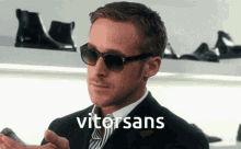a man wearing sunglasses and a suit has the word vitorsans on his face