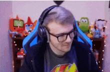 a man wearing glasses and headphones is sitting in a blue chair