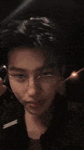 a young man wearing glasses and a ring on his finger takes a picture of himself